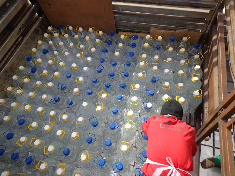 A team member helps to load the truck and ensure the bottles are tightly secured
